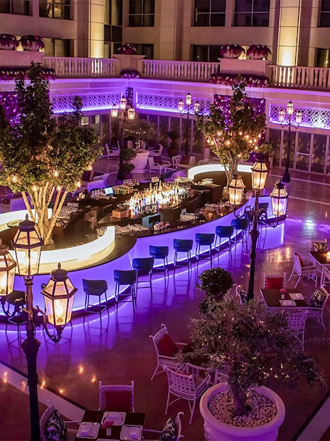 Outdoor dining area at Le Patio Restaurant with illuminated bar and seating, Dubai.