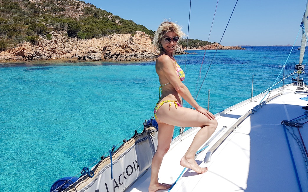 Sailboat excursion in La Maddalena Archipelago with clear blue waters and rocky coastline.