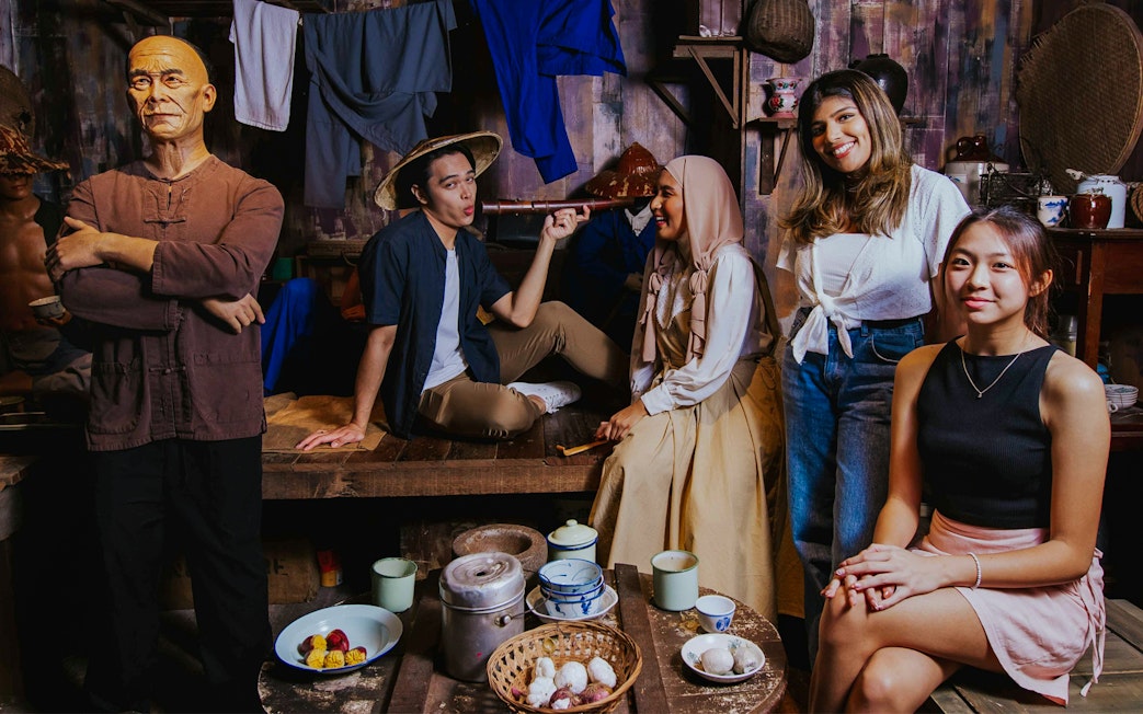 Visitors interacting in the Coolie Quarters exhibit at Madame Tussauds Singapore.