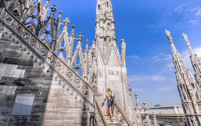 Visitor ascending stairs at the terrace of Duomo Cathedral, Milan.