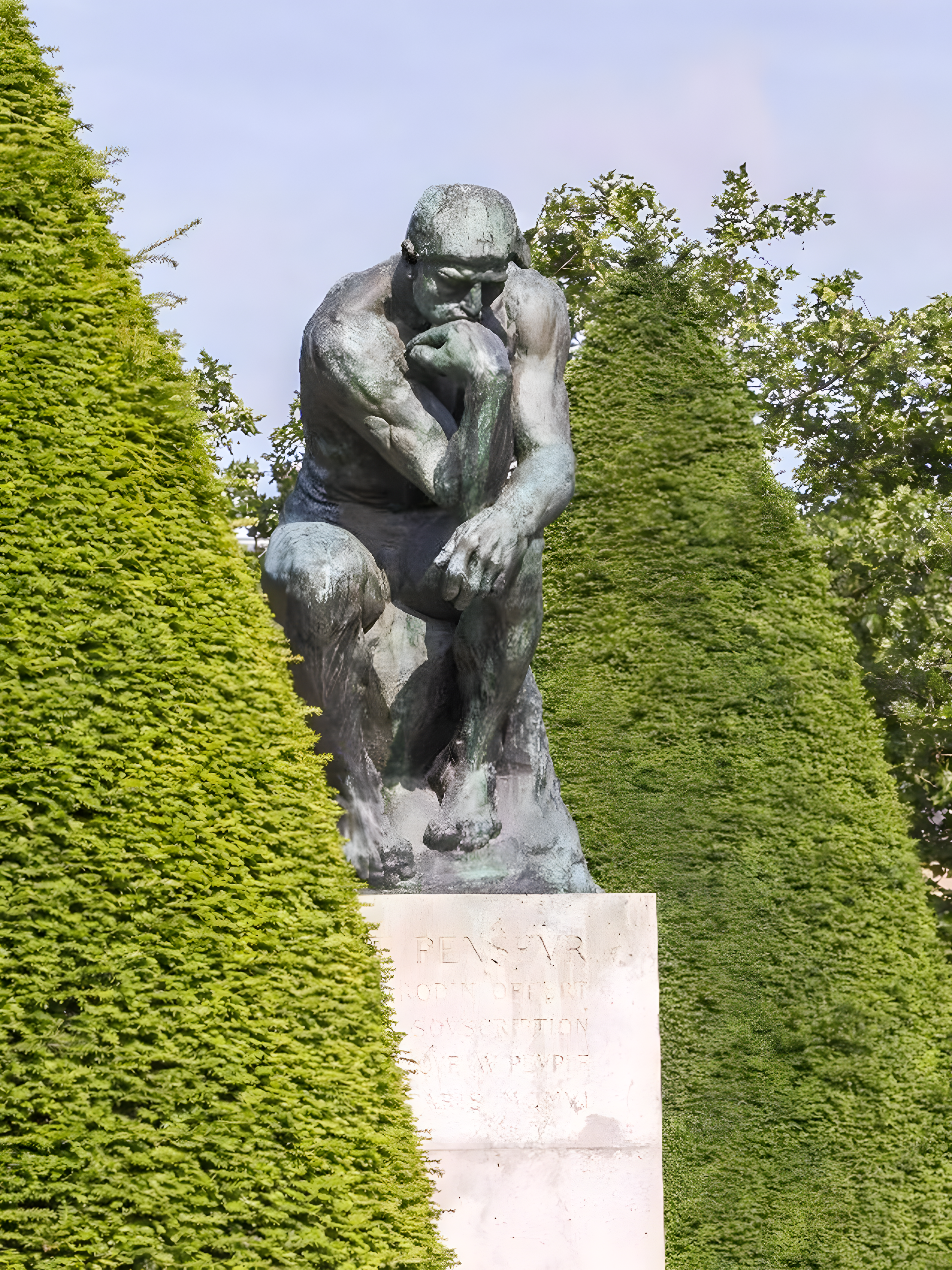 The Thinker sculpture at Rodin Museum surrounded by greenery.