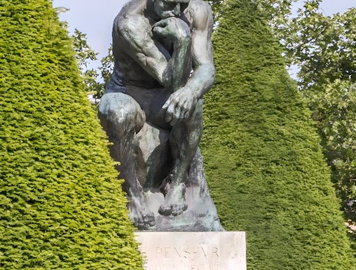 The Thinker sculpture at Rodin Museum surrounded by greenery.