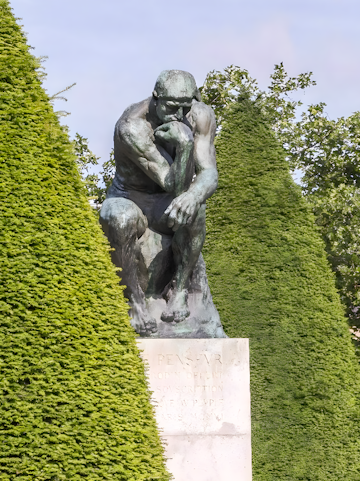 The Thinker sculpture at Rodin Museum surrounded by greenery.