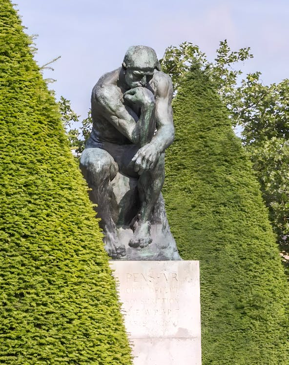 The Thinker sculpture at Rodin Museum surrounded by greenery.