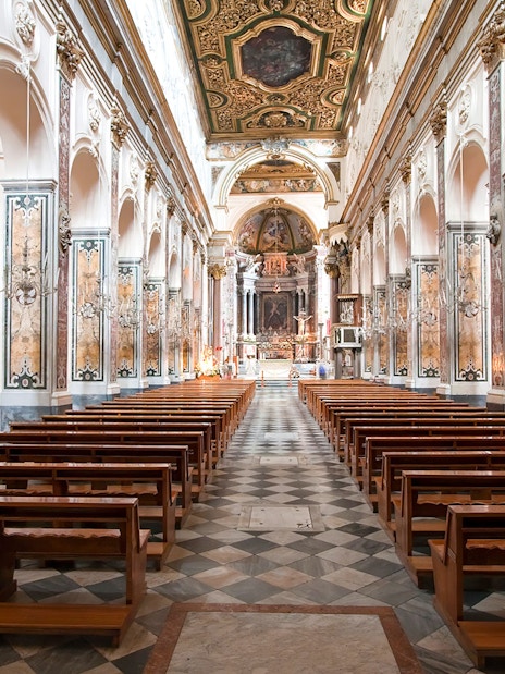 Interior of Amalfi Cathedral with ornate columns and wooden pews, Amalfi Coast.