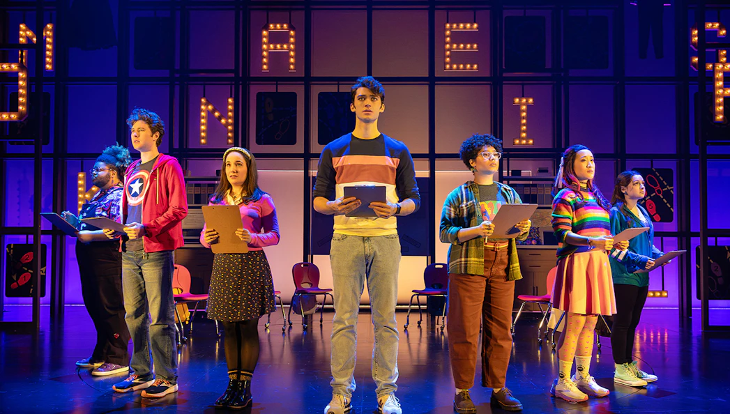 Performers on stage holding clipboards during "How to Dance in Ohio" show.
