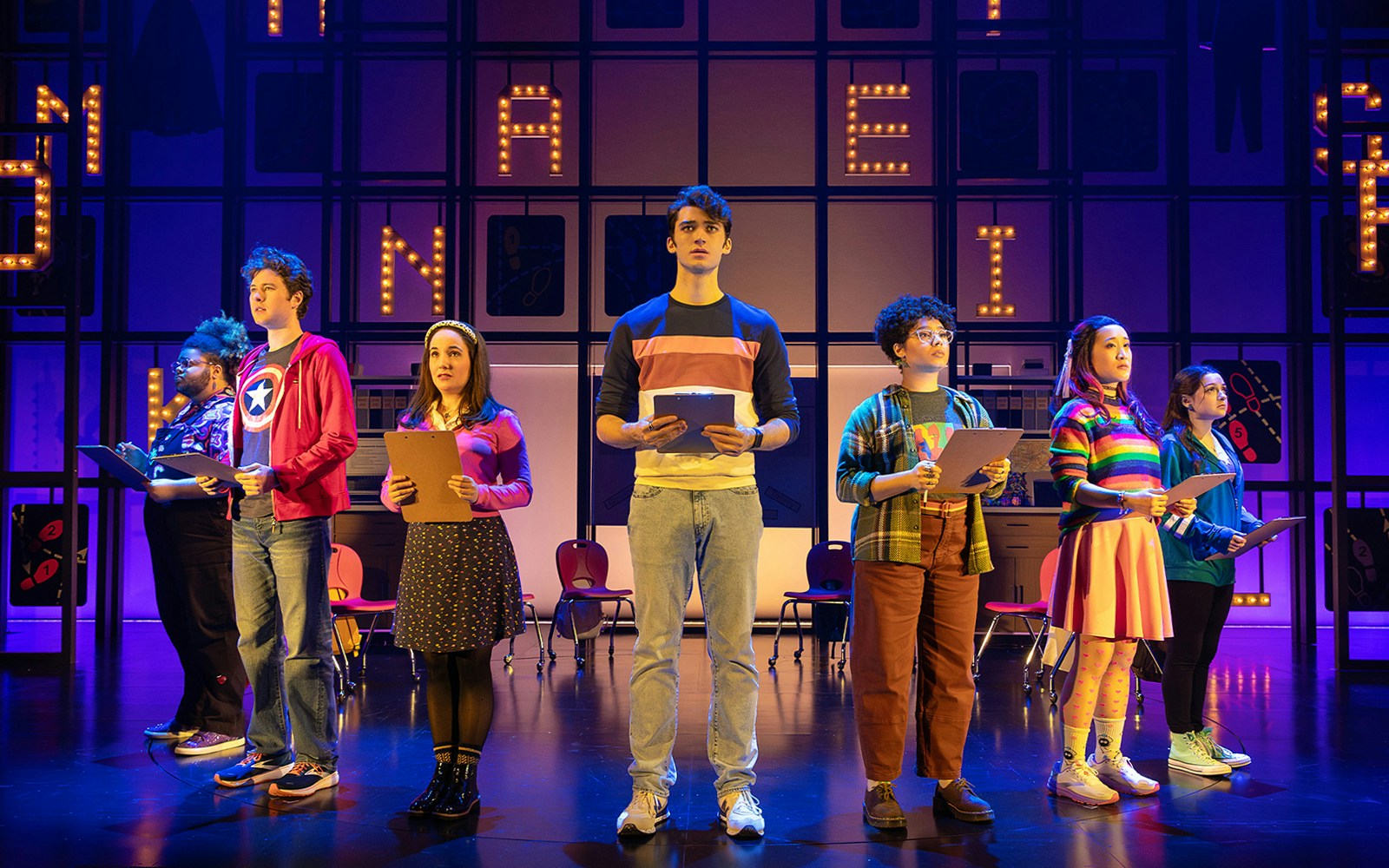 Performers on stage holding clipboards during "How to Dance in Ohio" show.