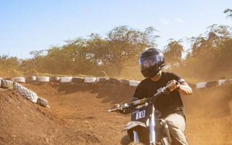 Electric dirt bike rider on a dusty track in Oahu with expert guidance.