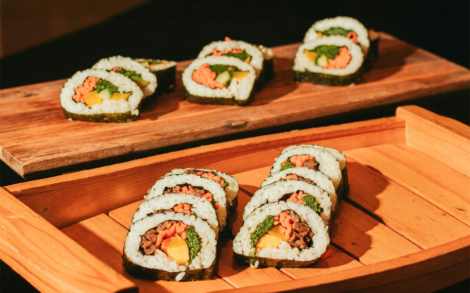 Sushi rolls served on wooden platters at Na Lei Aloha Luau, Waikīkī.
