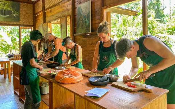 Participants chopping ingredients at a Bali farm cooking class.
