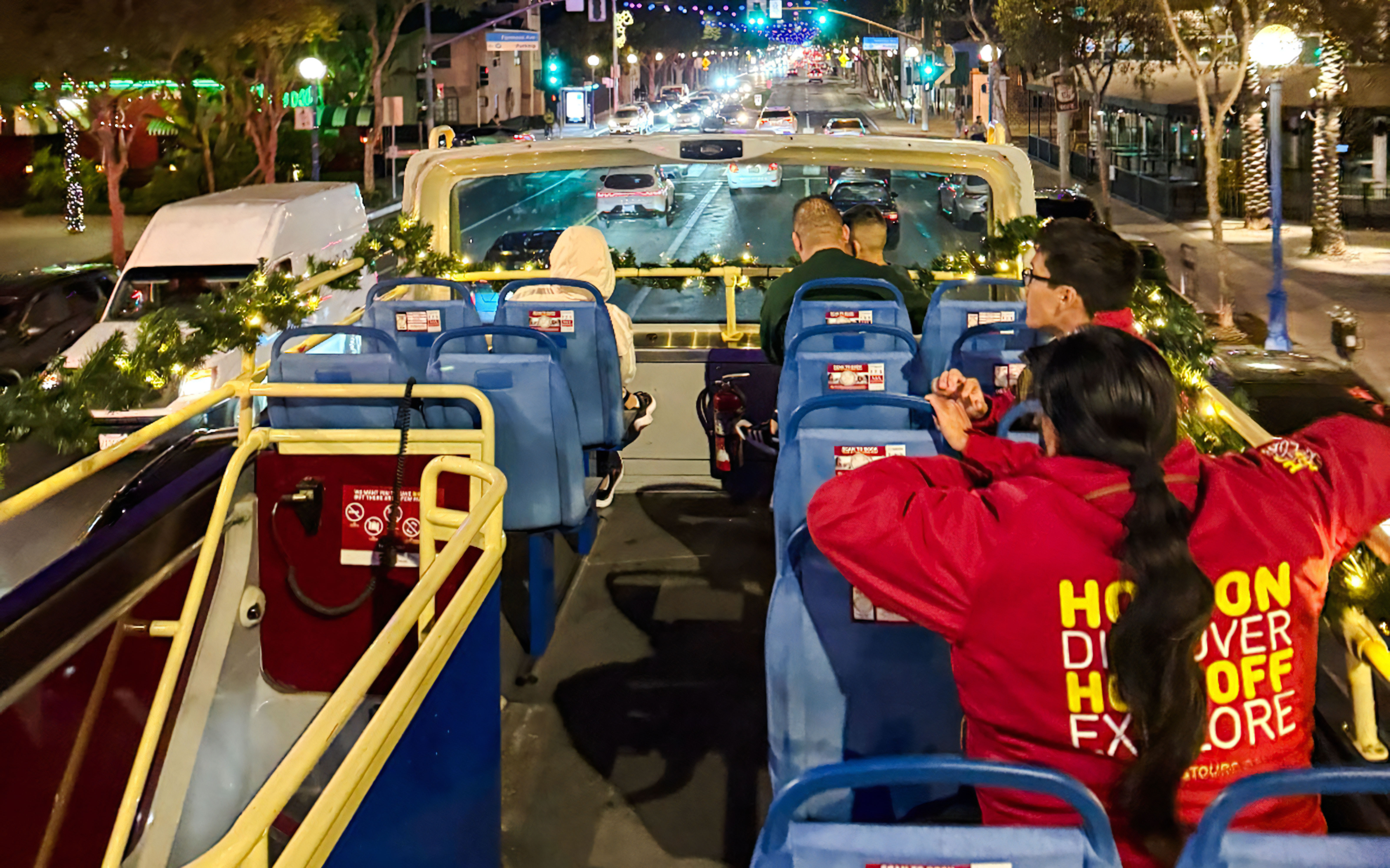 Tourists on Los Angeles HOHO bus during Holiday Lights Tour at night.