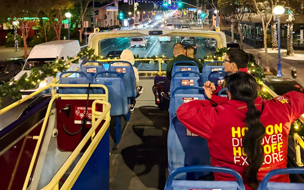 Tourists on Los Angeles HOHO bus during Holiday Lights Tour at night.