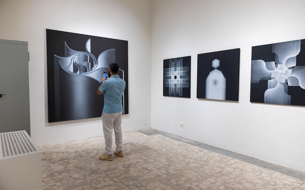 Visitor photographing abstract art at Palazzo delle Papesse exhibition in Siena.