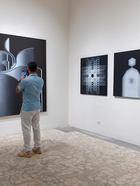 Visitor photographing abstract art at Palazzo delle Papesse exhibition in Siena.