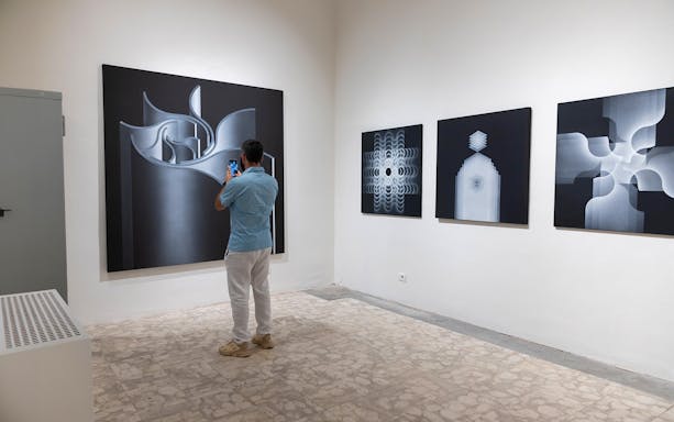 Visitor photographing abstract art at Palazzo delle Papesse exhibition in Siena.