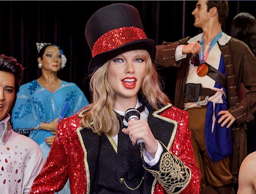 Performer wax figure in red and black costume at Wax Museum Madrid.