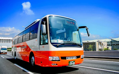 Tokyo Airport Limousine Bus driving on highway with cityscape background.