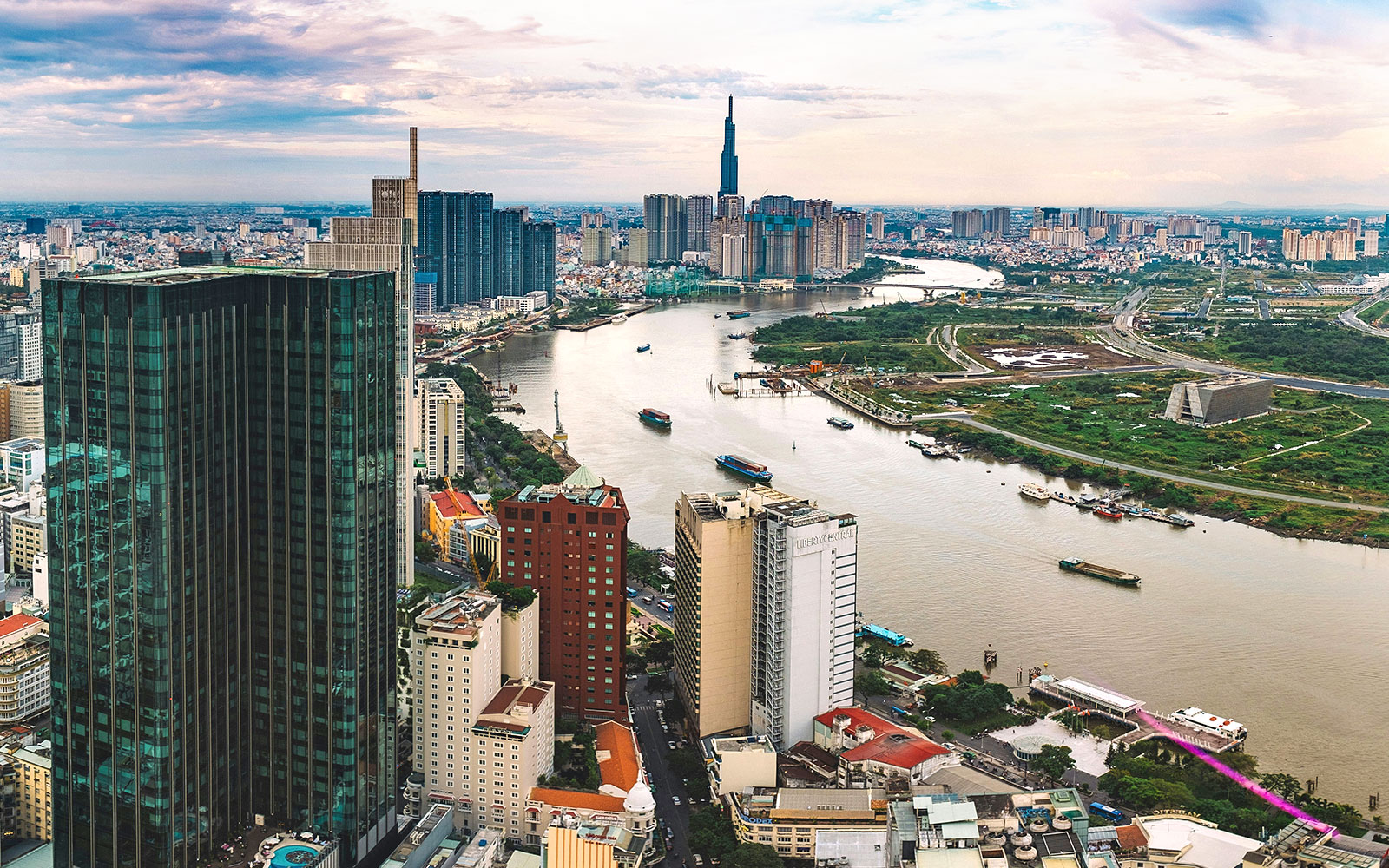 Panoramic view of downtown Ho Chi Minh City from a sky deck, featuring the Saigon River and skyscrapers.
