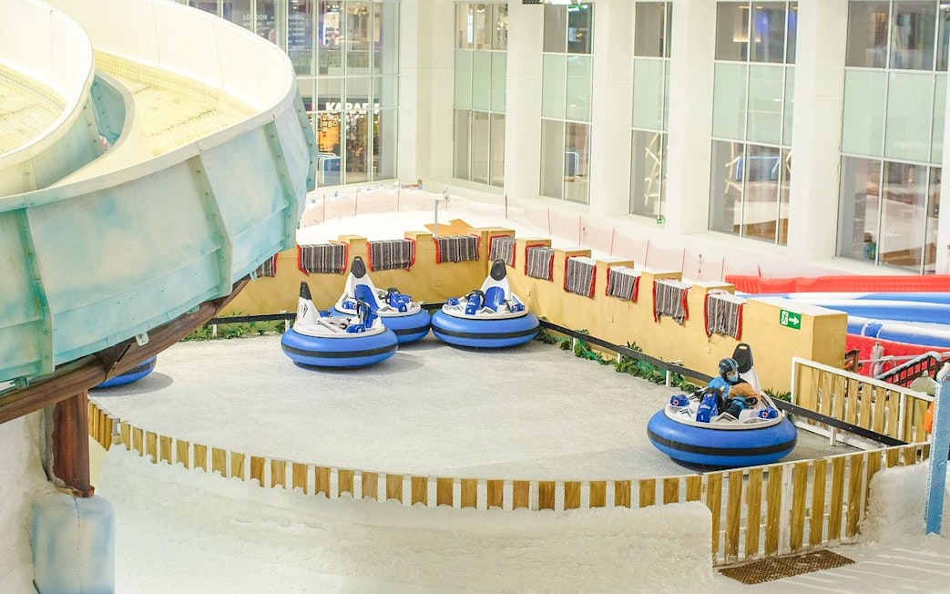 Bumper cars on snow at Snow Dunes Theme Park indoor attraction.