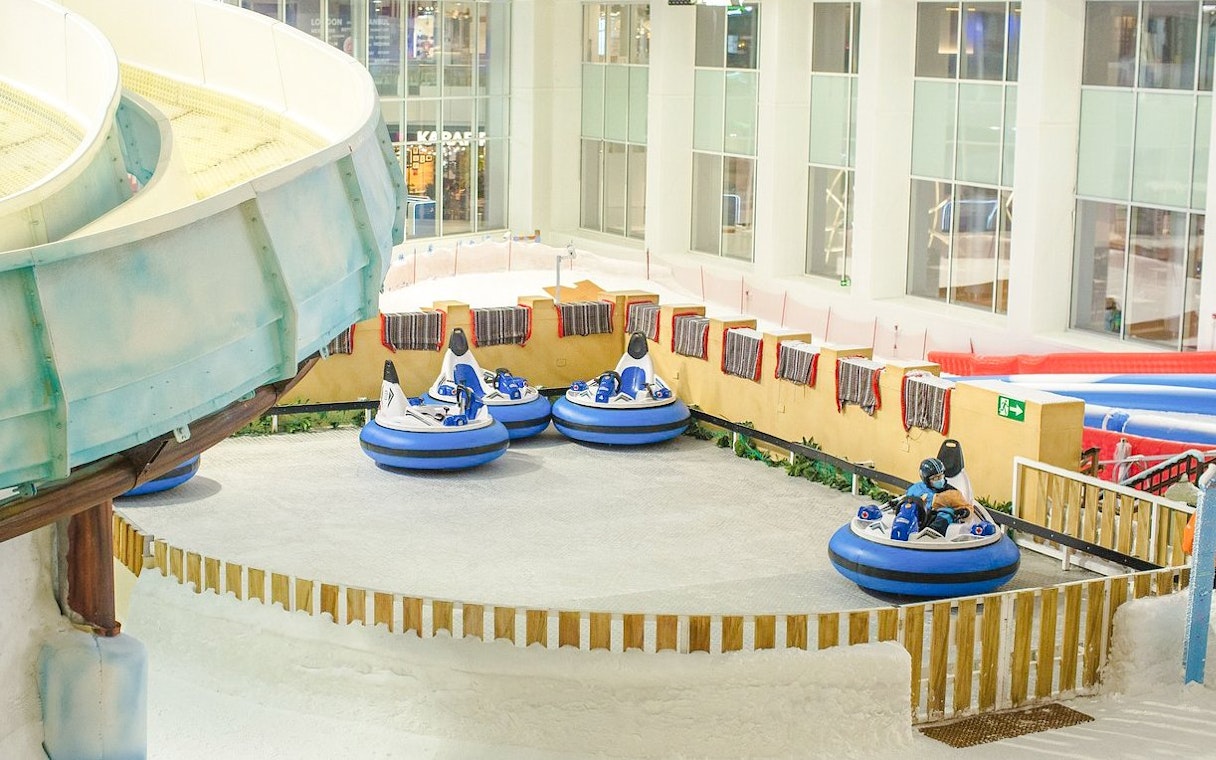 Bumper cars on snow at Snow Dunes Theme Park indoor attraction.