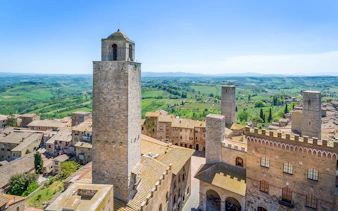 Aerial view of San Gimignano towers and surrounding Tuscan countryside.
