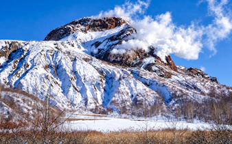 Snow-covered Mount Usu with steam vents in Hokkaido during winter.