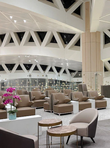 Plaza Premium Lounge seating area with modern chairs and tables, Riyadh airport.