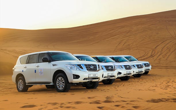 Four SUVs parked on Dubai desert sand during Red Dunes Desert Safari.