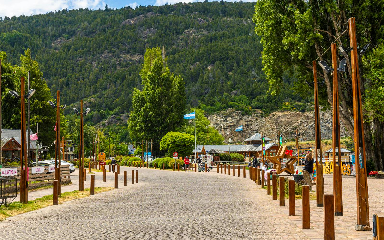 Promenade along the waterfront with flags and shops in San Martín de los Andes.