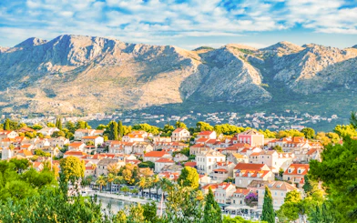 Panoramic view of Cavtat town with red-roofed buildings and mountains, south Dalmatia, Croatia.