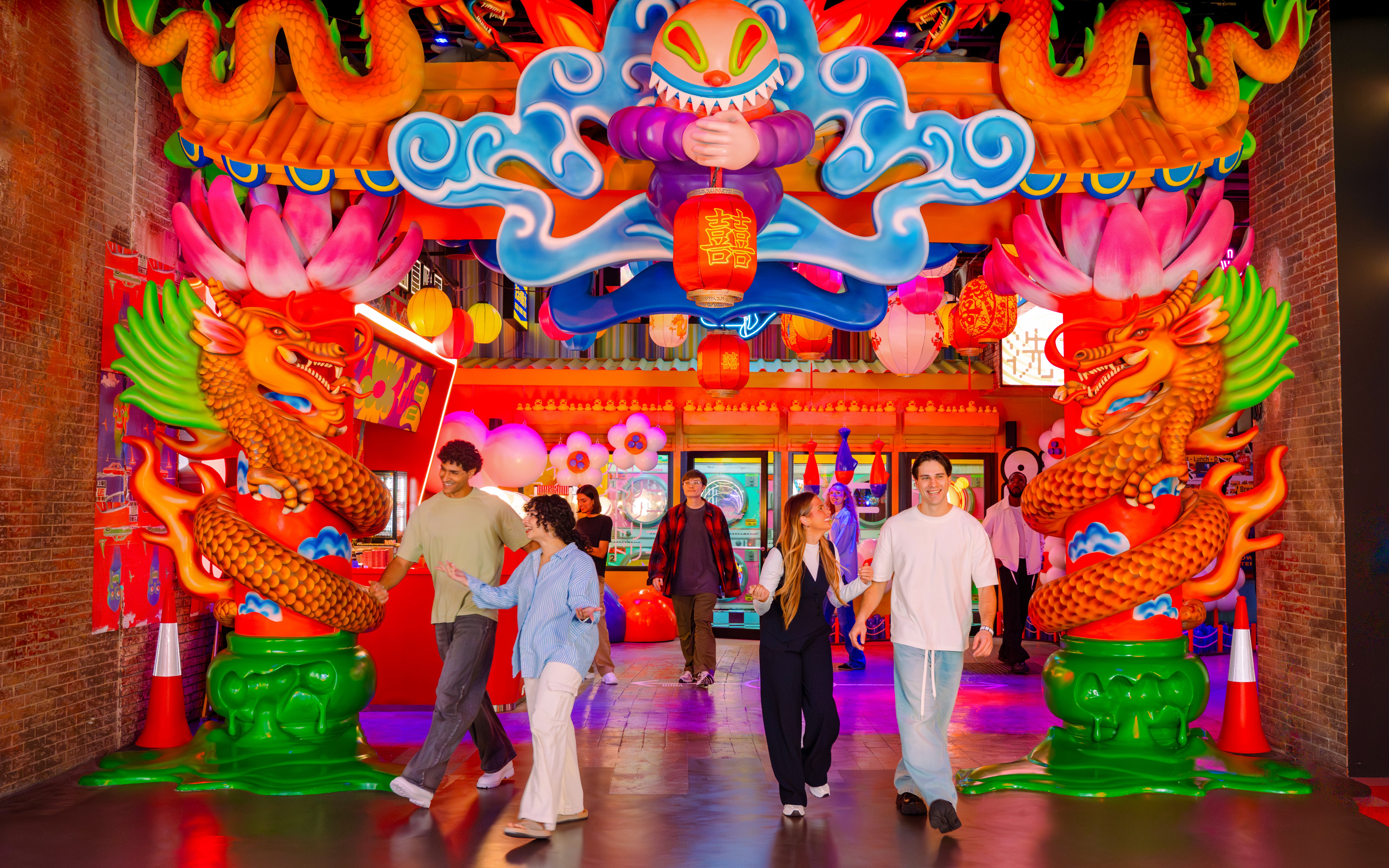 Visitors exploring vibrant dragon-themed entrance at House of Hype.