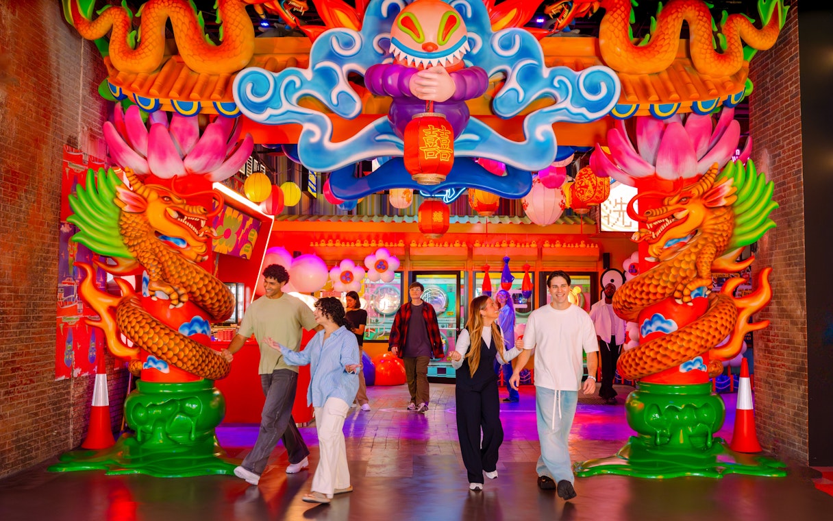 Visitors exploring vibrant dragon-themed entrance at House of Hype.