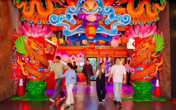 Visitors exploring vibrant dragon-themed entrance at House of Hype.