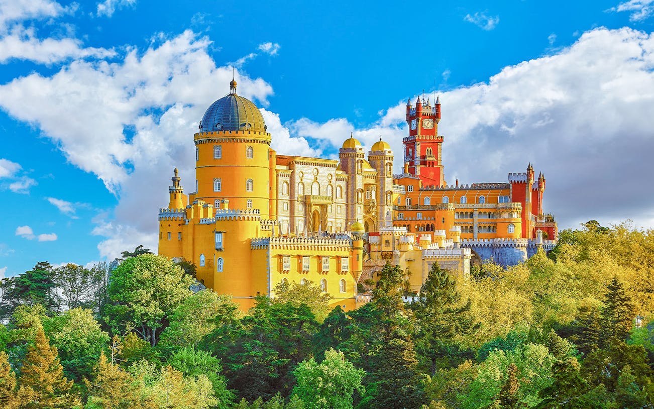 Pena Palace in Sintra, Portugal, with vibrant colors and lush forest surroundings.