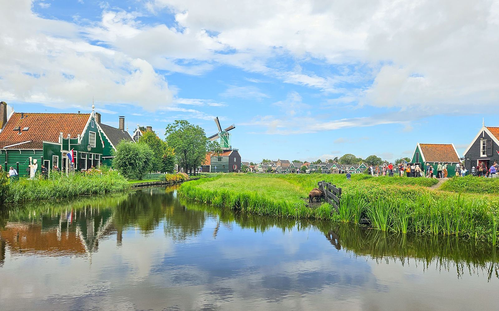 Giethoorn canal with traditional houses and windmill in Zaanse Schans day tour.