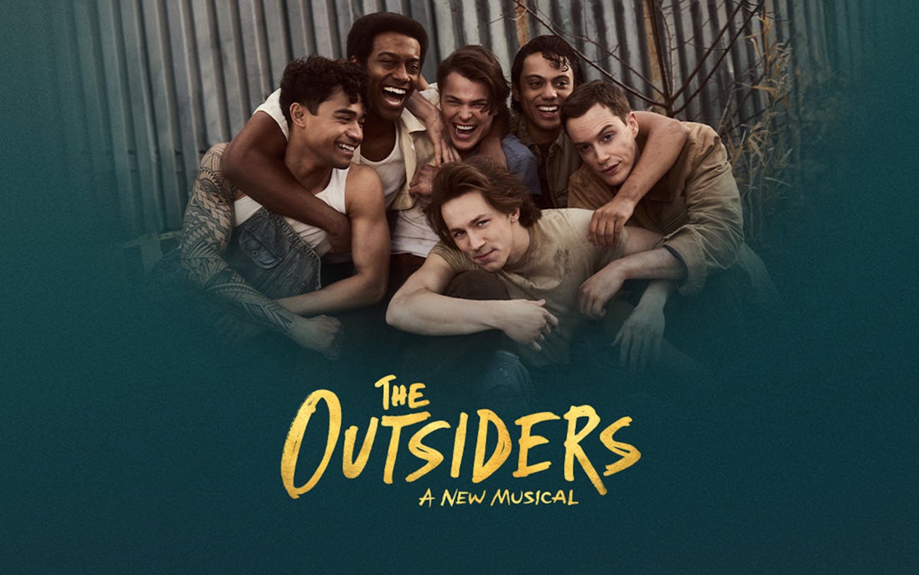 Cast of "The Outsiders" musical smiling together.