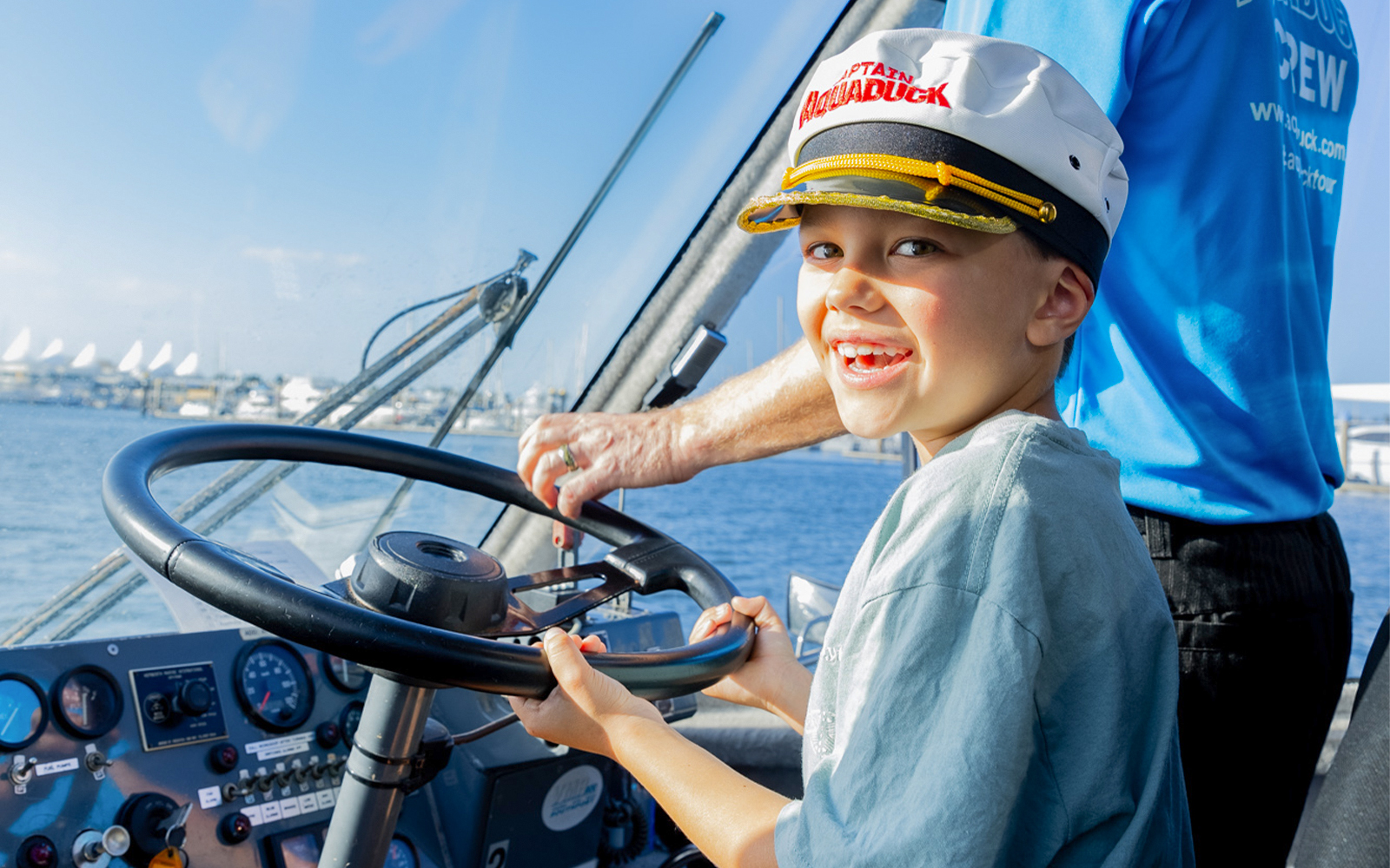 Child steering Aquaduck boat during Gold Coast river cruise.