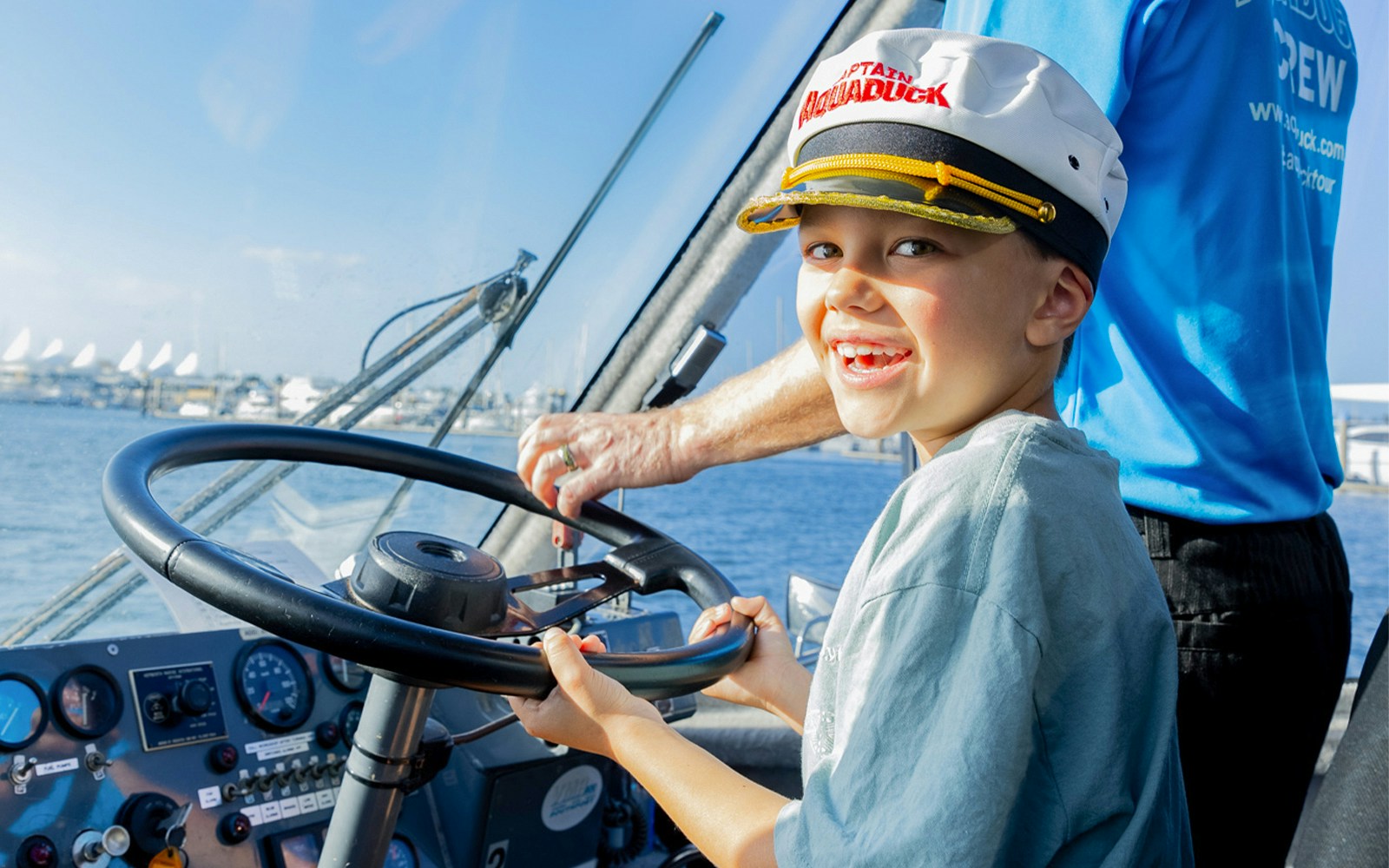 Child steering Aquaduck boat during Gold Coast river cruise.