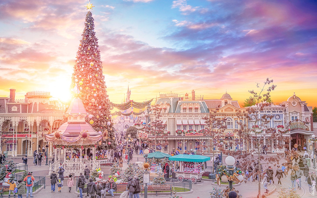 Disneyland Paris decorated for Christmas 2025 with a large tree and festive street scene.