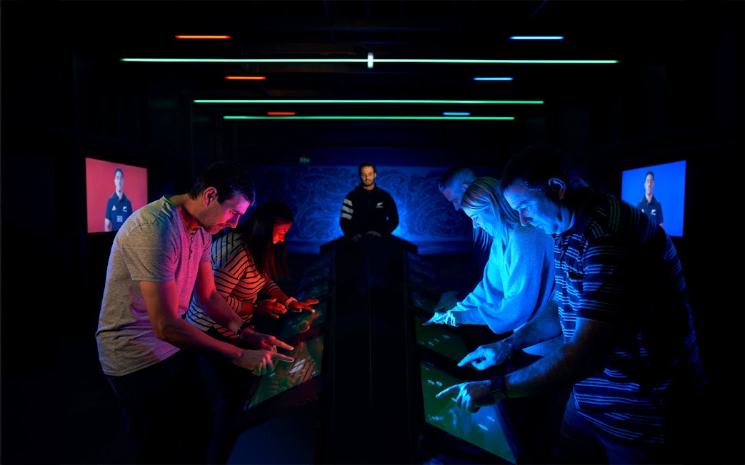 Visitors interact with digital displays at the All Blacks Experience in New Zealand.