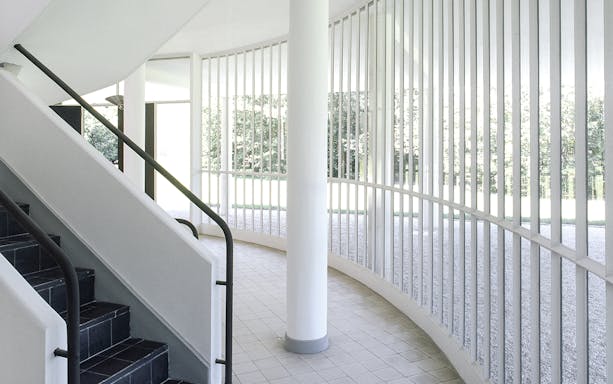Villa Savoye entrance hall with curved staircase and large windows.