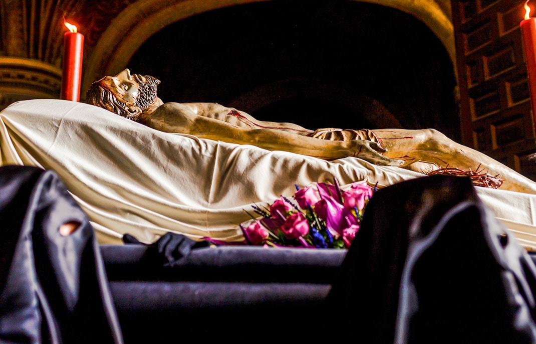 Holy Week procession in Florence with Nazarenes carrying Christ's statue.