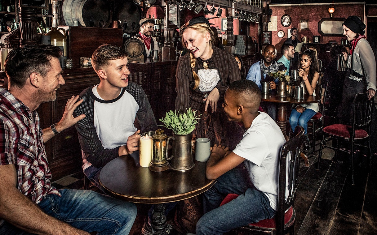 Guests enjoying drinks at a themed tavern as part of the London Dungeon premium package.