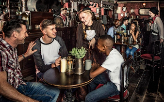 Guests enjoying drinks at a themed tavern as part of the London Dungeon premium package.