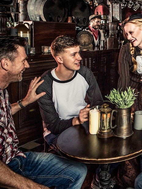 Guests enjoying drinks at a themed tavern as part of the London Dungeon premium package.