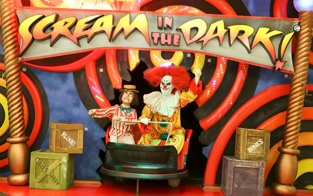 Clown figures in a ride at Ripley's Believe It Or Not! Museum with "Scream in the Dark" sign.