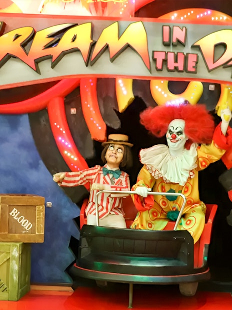 Clown figures in a ride at Ripley's Believe It Or Not! Museum with "Scream in the Dark" sign.