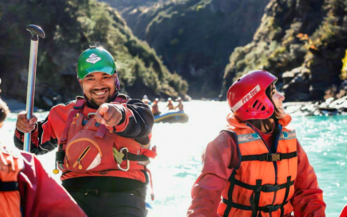 Whitewater rafters smiling on Shotover River, Queenstown adventure.