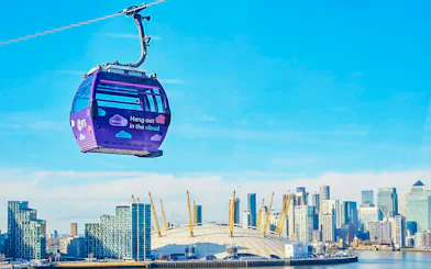 London IFS Cable Car with city skyline and O2 Arena in the background.