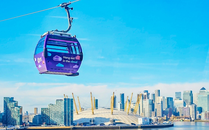 London IFS Cable Car with city skyline and O2 Arena in the background.